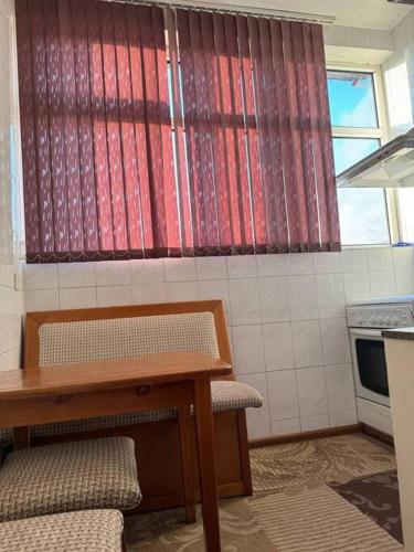 a kitchen with a table and a table and a window at Apartment in Samarkand