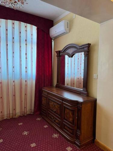 a room with a dresser with a mirror on it at Apartment in Samarkand