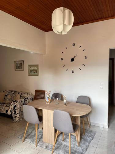 a dining room with a table and a clock on the wall at My Sweet Home in Tríkala