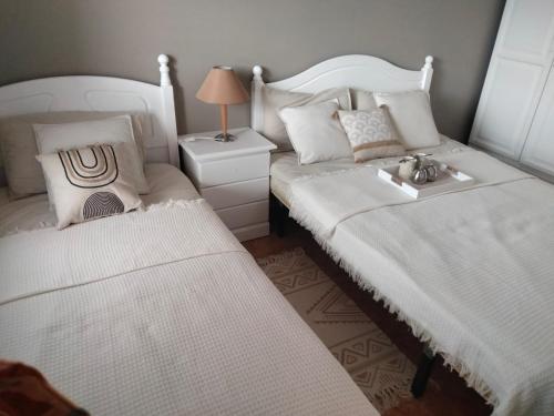 um quarto com duas camas e um candeeiro sobre uma mesa em Diamante de la Bahia em Caleta de Fuste