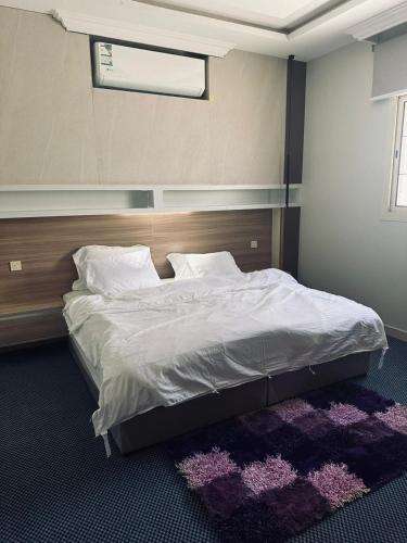 1 dormitorio con 1 cama grande y cabecero de madera en شقة مفروشة خاصة 1, en Tabuk