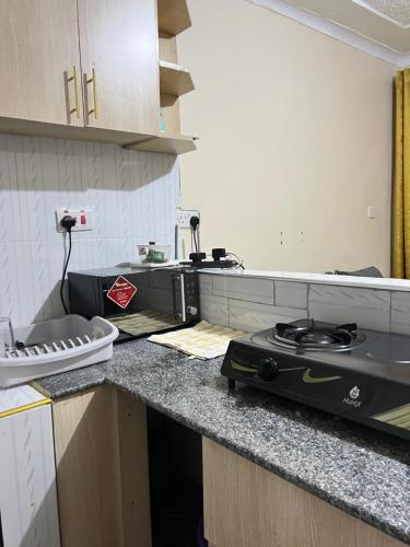 uma cozinha com uma placa de fogão num balcão em The comfort place Eldy em Eldoret