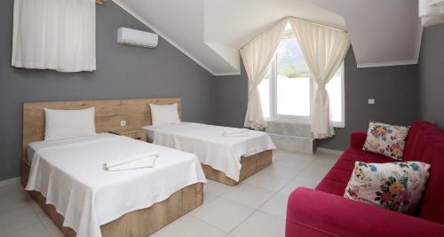 a room with two beds and a red couch at Villa Raya 1 in Fethiye