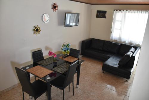 a living room with a table and chairs and a couch at Confortable apartamento cerca de la plaza principal in Villa de Leyva