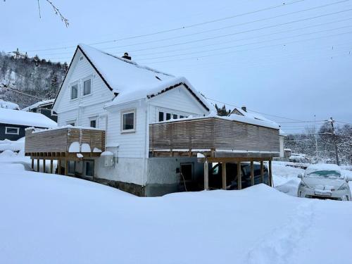 a white house with snow on the roof at Stort, koselig hus i naturområde in Bergen
