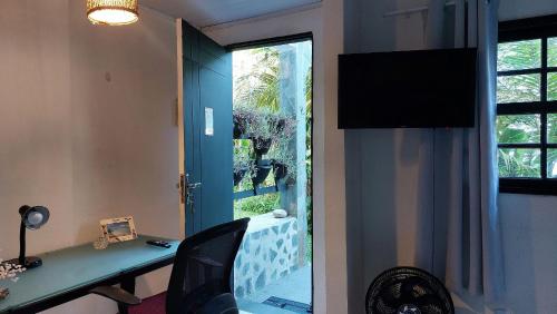 Habitación con escritorio y puerta de cristal con ventana. en Lofts da Monica, en Río de Janeiro