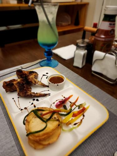 a plate of food on a table with a drink at Royal Highness Lux Guesthouse in Carletonville