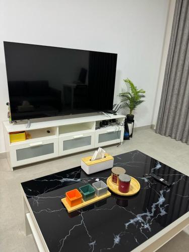 a living room with a entertainment center with a tv at Al jada apartment Sharjah in Sharjah