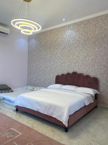 a bedroom with a large bed with a large headboard at مزرعه فلج المعلا in Falaj al Mu‘allá