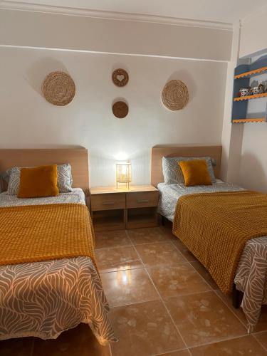 Cette chambre comprend 2 lits et une table. dans l'établissement Casa de Mila, à Alicante