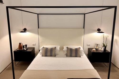 a bedroom with a canopy bed with two night stands at Ortigia Suite 15, Sicily Luxury Apt with hot tub in Siracusa