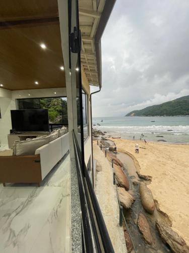 a room with a view of a beach and the ocean at Recanto Luxo Vista Mar in Angra dos Reis