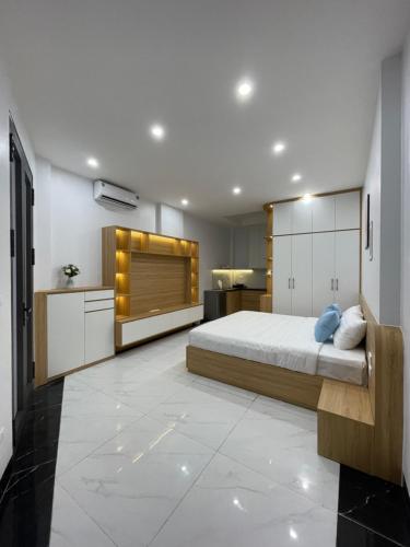 a bedroom with a large bed and a kitchen at Dodo home AC in Hanoi