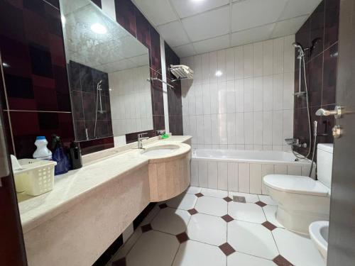 La salle de bains est pourvue d'un lavabo, d'une baignoire et de toilettes. dans l'établissement Burj Al saadah Al mamzar sharjah, à Charjah