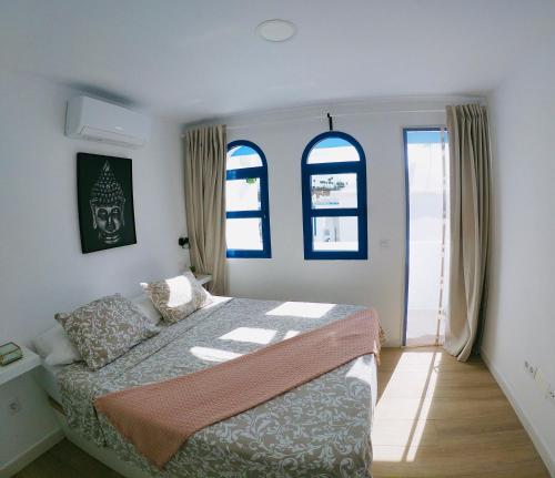 a bedroom with a bed and two windows at Bungalow Terrace&Pool near the Beach in Maspalomas