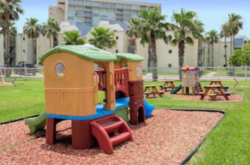 a playground in a park with tables and a play structure at Luxury Beachfront Condo with Private Pool &Terrace in South Padre Island