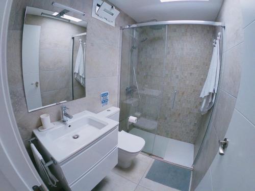 ein Bad mit einem WC, einem Waschbecken und einer Dusche in der Unterkunft Bungalow Terrace&Pool near the Beach in Maspalomas
