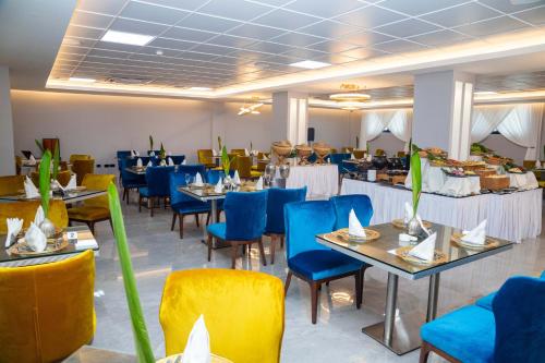 un comedor con mesas y sillas azules en Oak Plaza Hotels East Airport en Accra