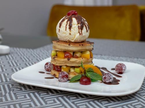 a plate with a stack of food on a table at Oak Plaza Hotels East Airport in Accra