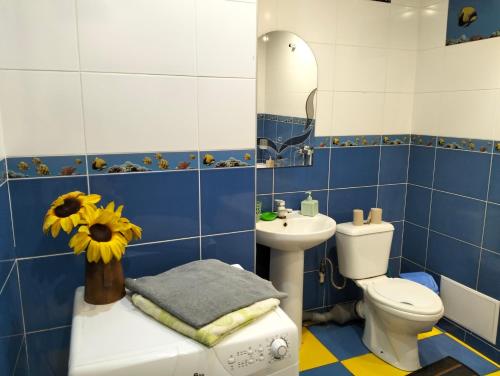a blue and white bathroom with a toilet and a sink at Apartment on 8 Marta Street in Mykolaiv
