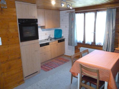 eine Küche mit einem Tisch und eine Küche mit einem Herd in der Unterkunft Apartment Enzian in Saas-Almagell