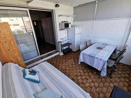une petite pièce avec une table et une cuisine dans l'établissement Résidence Les Nefs Des Sables - STUDIO 4 PERSONNES 5 couchages PORT LEUCATE. Réf: 2NEF_24K4 MAE-6884, à Port-Leucate