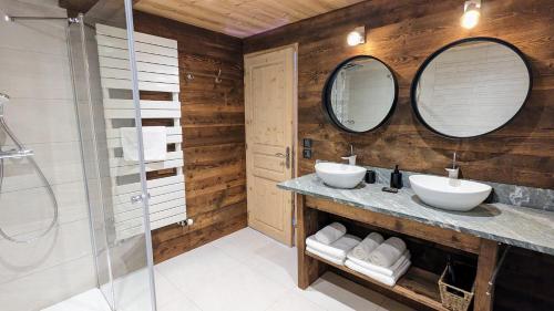 a bathroom with two sinks and two mirrors at Chalet Lè Lodzé - Pieds des pistes in La Rosière