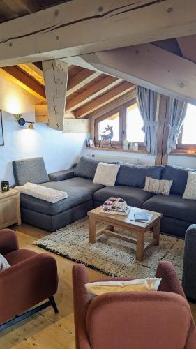 a living room with a couch and a coffee table at Chalet Lè Lodzé - Pieds des pistes in La Rosière