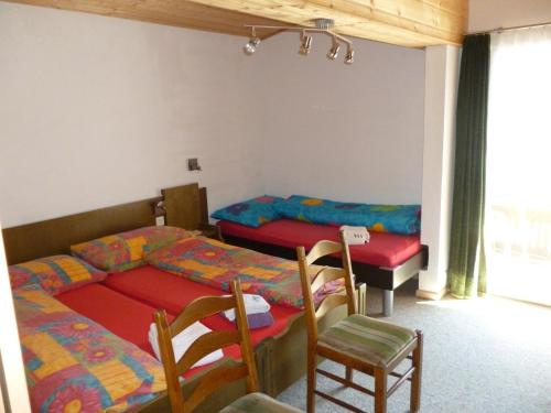 サース・アルマゲルにあるApartment Enzianのベッドルーム1室(ベッド2台、椅子、窓付)