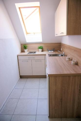 a small kitchen with a skylight and a sink at Koral Apartamenty 1 min od morza, kuchnia, taras, place zabaw in Sarbinowo