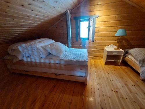 a bedroom with a bed in a log cabin at Villa kitkanhelmi in Kuusamo