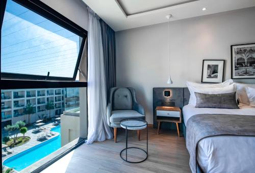 um quarto com uma cama, uma cadeira e uma janela em Dominium Palace em Agadir
