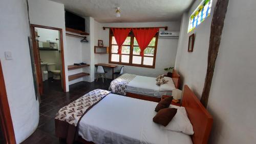 a bedroom with two beds and a window at Alma de cedrela in Puerto Ayora