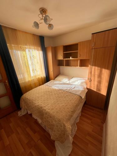 a small bedroom with a bed and wooden floors at Medeea in Zalău