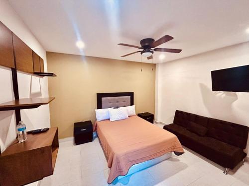een slaapkamer met een bed en een plafondventilator bij Hotel Casa 20 in León