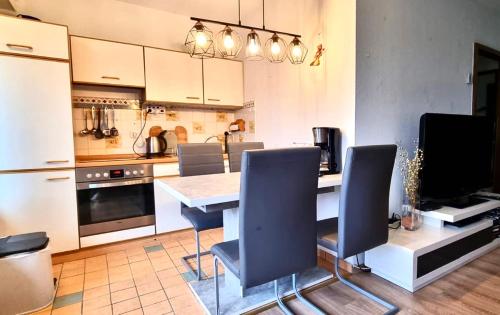 a kitchen with a table and chairs and a refrigerator at Panoramic Aparthotel in Braunlage