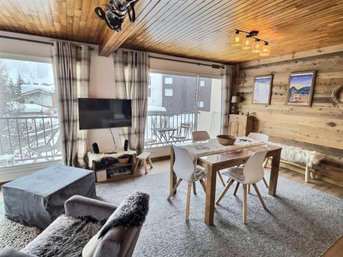un salon avec une table, des chaises et une télévision dans l'établissement Résidence La Balme - Magnifique 2 pièces entierement rénové pour 5 personnes MAE-5891, à Val dʼIsère