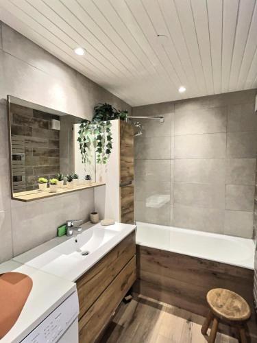 une salle de bain avec une baignoire et un lavabo et une baignoire dans l'établissement Résidence La Balme - Magnifique 2 pièces entierement rénové pour 5 personnes MAE-5891, à Val dʼIsère