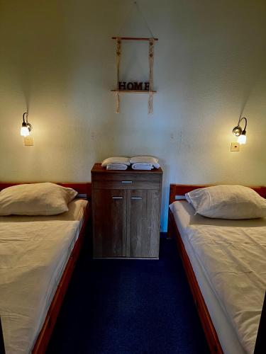 a room with two beds and a wooden cabinet at Panoramic Aparthotel in Braunlage