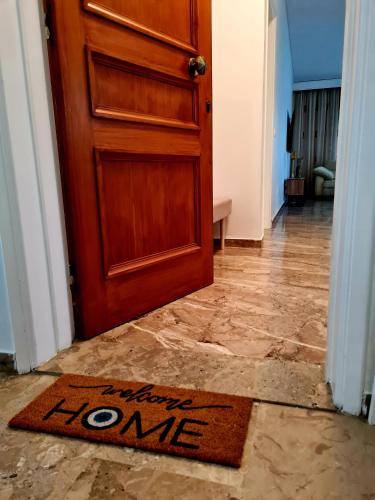 a welcome rug in front of a door with a welcome home sign at City Center Luxury Spacious apt A&M in Rhodes Town