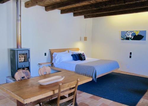 una camera con letto e tavolo in legno di Hotel La Tarjea a Real de Catorce