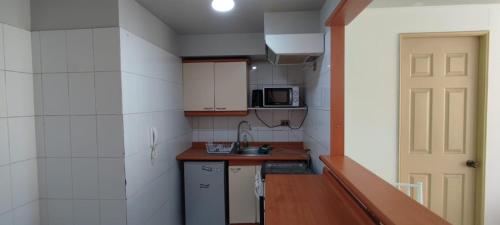 a small kitchen with a sink and a microwave at Departamento diario in Iquique