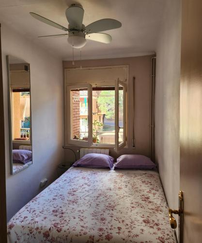 1 Schlafzimmer mit einem Bett, einem Ventilator und 2 Fenstern in der Unterkunft Habitación Elegante in Barcelona