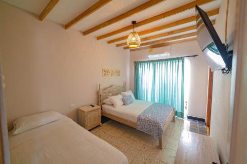 a bedroom with two beds and a window at Colonial Beach Airport Hotel in Cartagena de Indias
