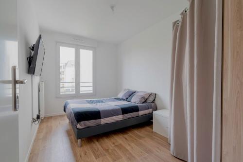 Habitación pequeña con cama y ventana en Spacieux appart JO2024 Parking Terrasse CDG 6 pers Wifi en Tremblay En France