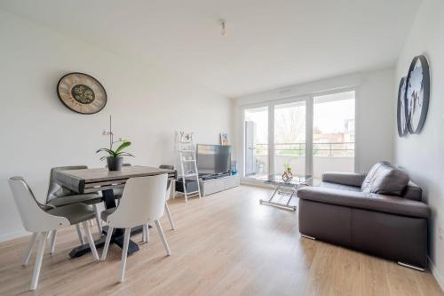 a living room with a couch and a table at Spacieux appart JO2024 Parking Terrasse CDG 6 pers Wifi in Tremblay En France
