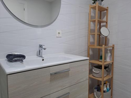 a bathroom with a sink with a mirror and a shelf at Luxury Sea View Senator Lanzarote in Costa Teguise