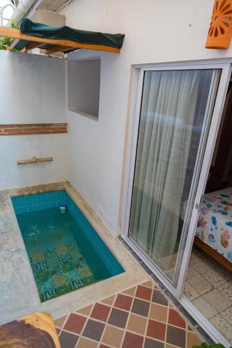 a small swimming pool in a room with a window at Colonial Beach Airport Hotel in Cartagena de Indias