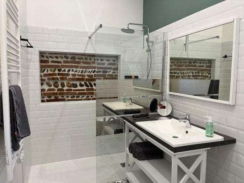 une salle de bain blanche avec deux lavabos et un miroir dans l'établissement Appt au MEETT, Airbus, Aéroport, à Aussonne