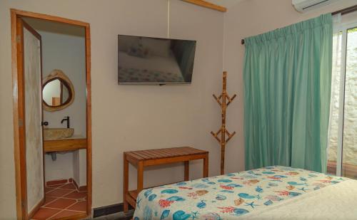 a bedroom with a bed and a mirror at Colonial Beach Airport Hotel in Cartagena de Indias